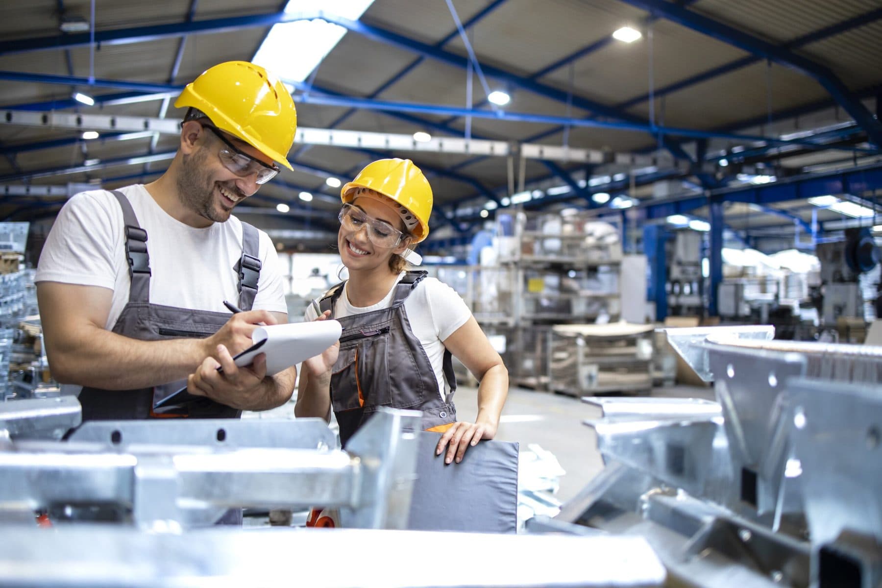 Equipo trabajando en una planta industrial revisando piezas de acero