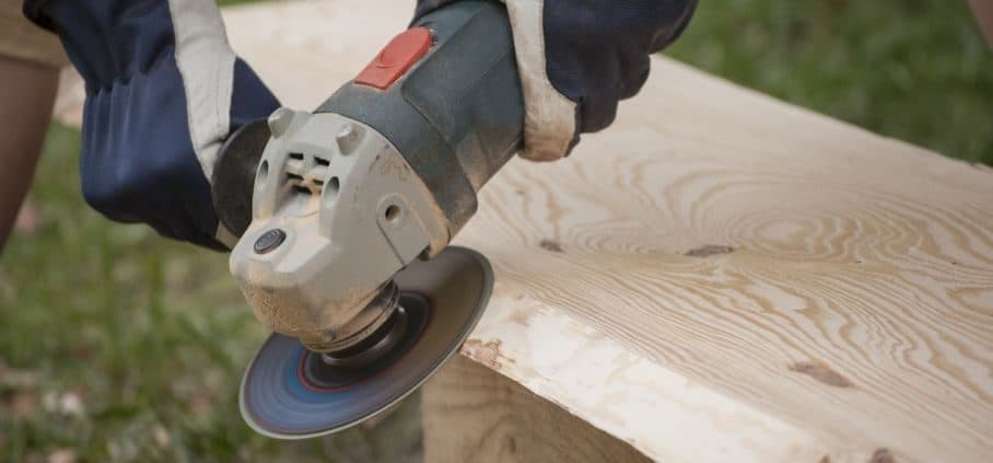 Amoladora angular cortando una tabla de madera, primer plano
